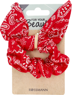 Czerwona ozdobna gumka do włosów scrunchie z białym wzorem paisley, na brązowej podkładce Rossmann.