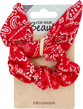 Czerwona ozdobna gumka do włosów scrunchie z białym wzorem paisley, na brązowej podkładce Rossmann.