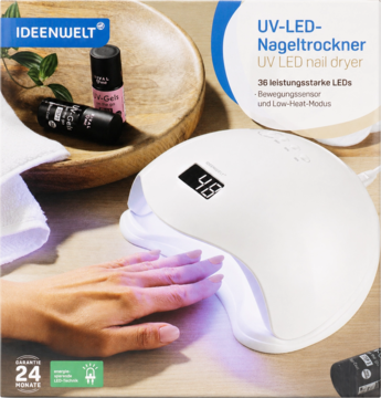 Biała lampa UV LED do paznokci Ideenwelt z wyświetlaczem, dłoń w środku, na drewnianym tle z akcesoriami do manicure.