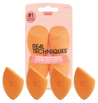 4 pomarańczowe gąbeczki Real Techniques Miracle Complexion Sponge, dwie w różowym opakowaniu, dwie leżące obok.
