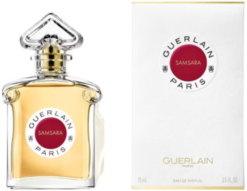 Złota woda perfumowana Guerlain Samsara w przezroczystej butelce obok białego opakowania z czerwonym logo.
