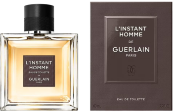 Guerlain L'Instant Homme EDT w bursztynowej butelce obok czekoladowego opakowania, widok z przodu.