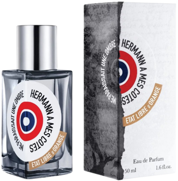 Woda perfumowana Etat Libre d’Orange Hermann, szklana butelka z etykietą w kształcie tarczy i pudełko, widok przodem.