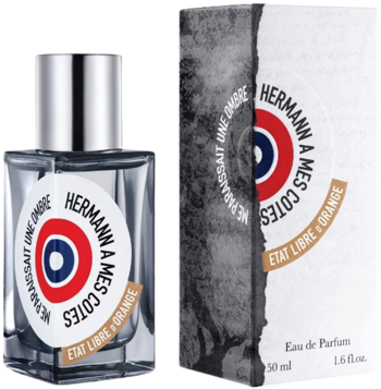 Woda perfumowana Etat Libre d’Orange Hermann, szklana butelka z etykietą w kształcie tarczy i pudełko, widok przodem.