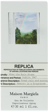Maison Margiela Replica When the Rain Stops EDT w białym pudełku, z obrazem tęczy widocznej przez okno.