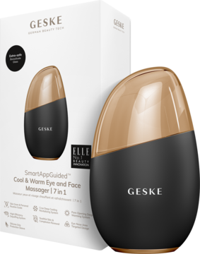 Masażer GESKE Cool & Warm 7w1, czarno-złoty, jajowaty, stoi przed białym pudełkiem produktu.