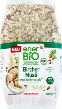 Wegańskie EnerBio Bircher Muesli bez cukru w przezroczystej torbie, z widocznymi płatkami, orzechami i jabłkami.