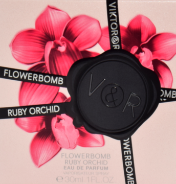 Różowe pudełko perfum Viktor & Rolf Flowerbomb Ruby Orchid z czerwonymi orchideami, czarną wstążką i pieczęcią V&R.