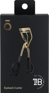 Złota zalotka Kashōki z czarnymi rączkami na czarnym opakowaniu. Widok z przodu, napis Eyelash Curler.