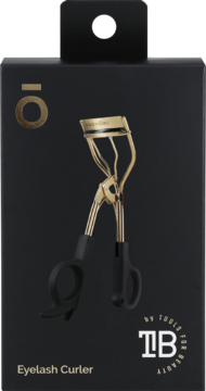 Złota zalotka Kashōki z czarnymi rączkami na czarnym opakowaniu. Widok z przodu, napis Eyelash Curler.