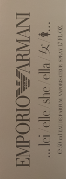 Pionowe, beżowe pudełko perfum Emporio Armani 50 ml. Z boku napisy "lei/elle/she/ella" i "EAU DE PARFUM".