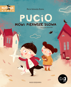 Okładka książki Pucio mówi pierwsze słowa: chłopiec Pucio, dziewczynka, pies na tle kolorowych domków. Wspiera mowę dzieci.
