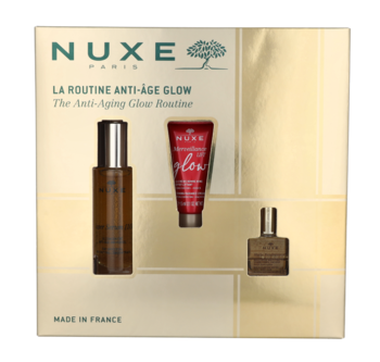 Zestaw Nuxe Paris Anti-Aging Glow z serum, kremem i olejkiem w złoto-białym pudełku, widok z przodu.