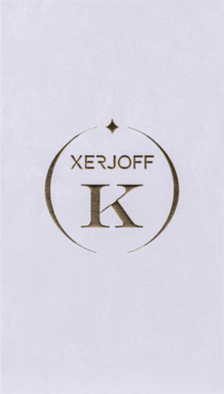Złote logo perfum Xerjoff K na białym, lekko teksturowanym tle. Okrągły kształt z napisem XERJOFF i dużą literą K.