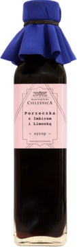 Butelka syropu Manufaktura Cieleśnica Porzeczka z imbirem i limonką, ciemny płyn, różowa etykieta, niebieski kapturek.