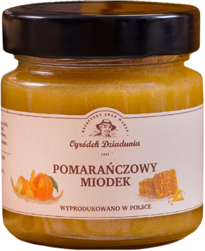 Miód pomarańczowy Ogródek Dziadunia w szklanym słoiku, z czarną nakrętką i etykietą z pomarańczą.