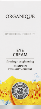 Białe opakowanie Organique Hydrating Therapy Eye Cream, z napisami Pumpkin i Caffeine, na tle dyni z kroplami wody.