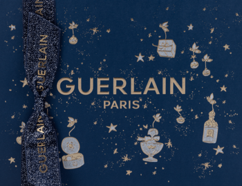 Zestaw prezentowy Guerlain Mon Guerlain: granatowe pudełko ze złotym logo, gwiazdkami i wstążką.
