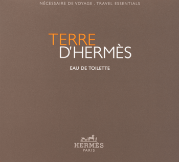 Brązowa grafika Terre D'Hermès Eau de Toilette z pomarańczowym napisem TERRE, białym D'HERMÈS, i logo Hermès.