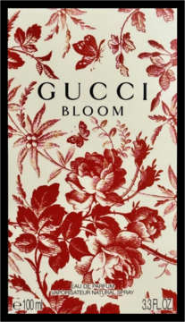 Gucci Bloom Eau de Parfum 100ml. Eleganckie, białe opakowanie z czerwonymi wzorami kwiatów i motyli, widok z przodu.