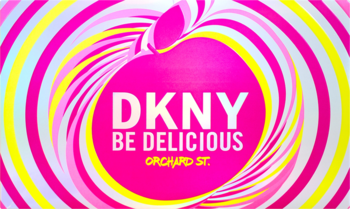 Reklama DKNY Be Delicious Orchard St. z wirującym tłem w kształcie jabłka w kolorach różu i żółci.
