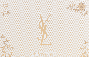 Logo Yves Saint Laurent w złotym kolorze na beżowym, koronkowym tle z delikatnymi, roślinnymi wzorami.