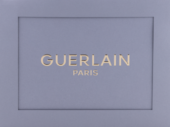 Opakowanie Guerlain L'Homme Ideal, fioletowy karton ze złotym, wytłoczonym logo GUERLAIN PARIS.