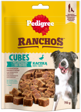 Frontowe ujęcie żółtej torebki Pedigree Ranchos Cubes 70g, kaczka, 100% naturalne przysmaki dla psa. Pies oblizuje pysk.