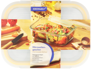 Szklany, dwukomorowy pojemnik mikrofalowy Ideenwelt, z pokrywką, wypełniony warzywami, na desce.