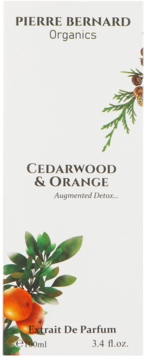 Białe pudełko Pierre Bernard Organics Cedarwood & Orange Extrait De Parfum, z gałązkami cedru i pomarańczy.