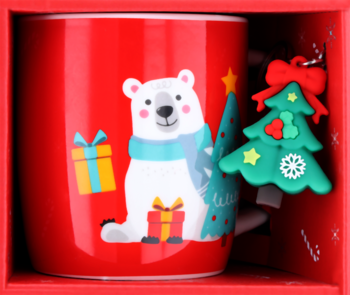 Czerwony kubek ceramiczny z misiem polarnym i choinką, obok zielona zawieszka choinka. Całość w czerwonym pudełku.
