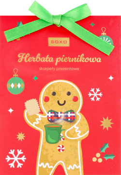 Czerwona torba prezentowa SOXO z zieloną wstążką, piernikowym ludzikiem i napisem 'Herbata piernikowa skarpety prezentowe'.