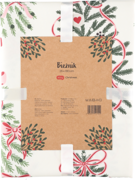 Biały świąteczny bieżnik z motywem choinki i czerwonymi wstążkami, złożony, z brązową etykietą.