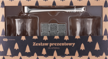 Zestaw prezentowy do whisky: dwie szklanki, szare kamienie chłodzące i metalowe szczypce, w brązowym pudełku z choinkami.