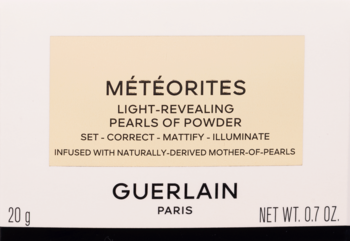 Zbliżenie na beżową etykietę pudru Guerlain Météorites Light-Revealing Pearls of Powder, czarny tekst.