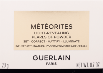 Guerlain MÉTÉORITES rozświetlający puder w kulkach. Przednie beżowe opakowanie z czarnym napisem.