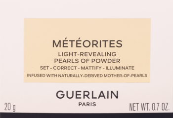 Guerlain Météorites, rozświetlający puder w perełkach. Białe opakowanie z beżową etykietą, zbliżenie.