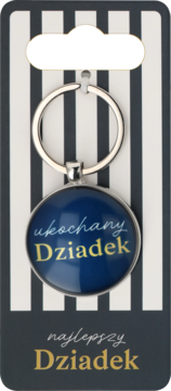 Srebrny metalowy brelok z okrągłym, granatowym medalionem i napisem "ukochany Dziadek", na tle w paski.