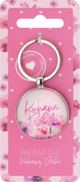 Srebrny brelok Eloy Najlepsza Babcia z napisem Kochana Babcia, różowymi kwiatkami, na różowym kartonie w serduszka.