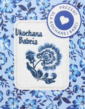Biały ręcznik z niebieskim haftem kwiatowym i napisem Ukochana Babcia, etykieta 'Prezent dla Babci'.