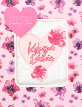 Prezentowy ręcznik dla babci: biały, puszysty, z haftowanym różowym sercem 'Kochana Babcia' na kwiecistym tle.