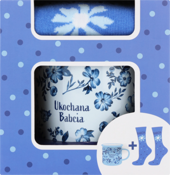 Zestaw dla babci: biały kubek z niebieskimi kwiatami i napisem Ukochana Babcia, niebieskie skarpetki w pudełku.