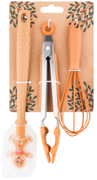 Świąteczny zestaw pomarańczowych akcesoriów kuchennych: łopatka z piernikowym ludzikiem, szczypce i trzepaczka na tle w liście.