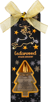 Czarny dyfuzor zapachowy Cedarwood w świątecznym opakowaniu ze złotą kokardą i widoczną butelką w kształcie choinki.