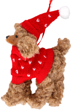 Pluszowy brązowy pudel w czerwonej świątecznej czapce z pomponem i sweterku w białe serca, widok z boku.