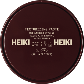 Ciemnobrązowa, okrągła puszka Heiki Texturizing Paste, średnie utrwalenie, matowe wykończenie, widok z góry.