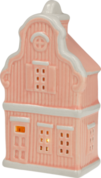 Różowy ceramiczny lampion w kształcie domku, z białymi detalami imitującymi śnieg i podświetlonymi oknami, widok pod kątem.