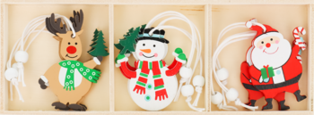 Zestaw trzech płaskich ozdób świątecznych: renifer, bałwan i Mikołaj, każdy z białym sznurkiem, w drewnianym pudełku.