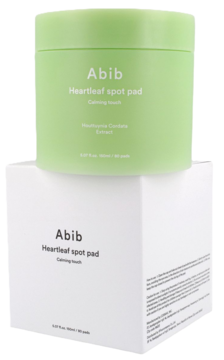Abib Heartleaf Spot Pad Calming Touch, zielony słoik z pstrolistką, na białym pudełku, pod kątem.