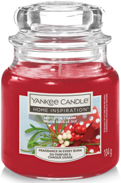 Yankee Candle Mistletoe Charm, czerwona świeca w szklanym słoiku z etykietą z ostrokrzewem, widok z przodu.